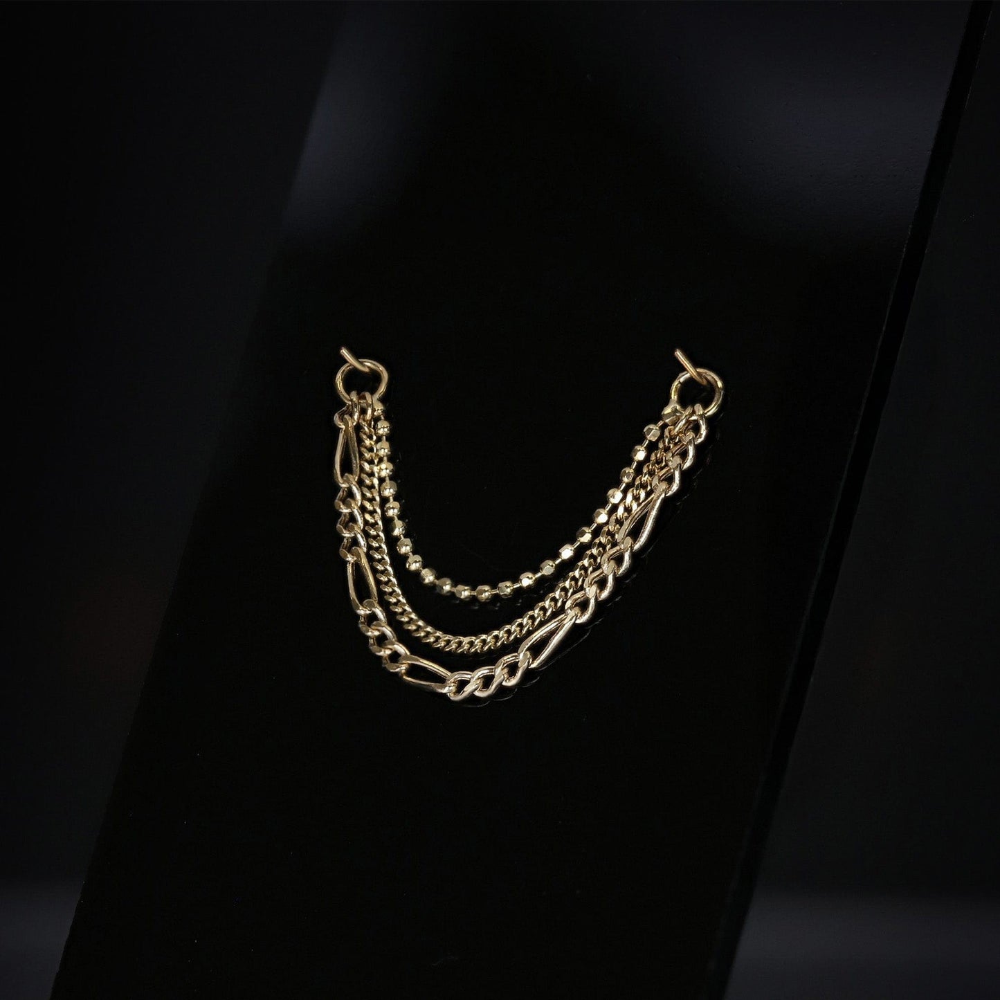 14K gold triple mixed chain attachment on a dark background