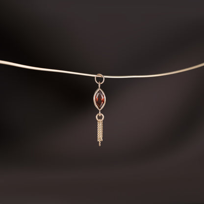 14K gold charm of a marquise-cut Garnet paired with three delicate gold curb chain tassels