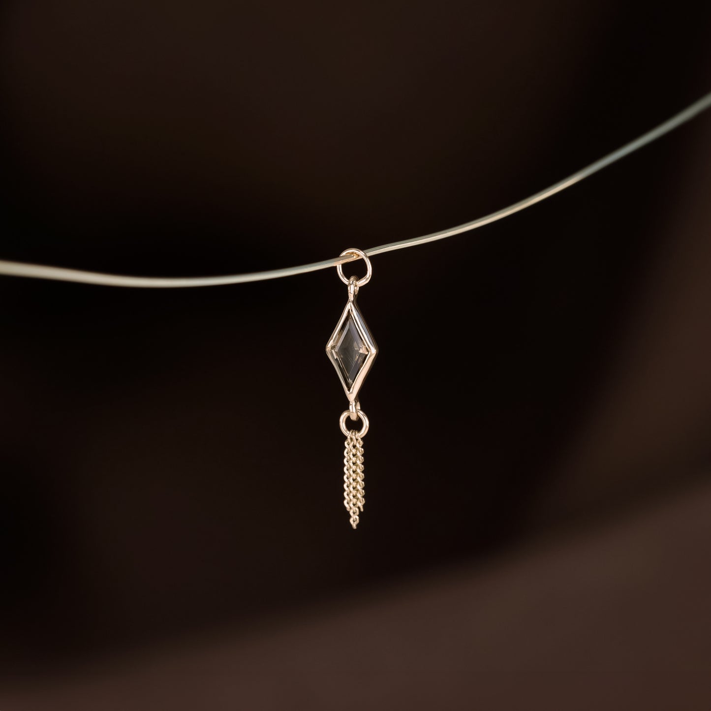 14K gold charm of a kite a Rhombus-cut Smoky Quartz paired with three delicate gold curb chain tassels