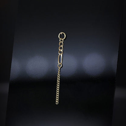 14K gold mixed-link drop chain charm on a dark background