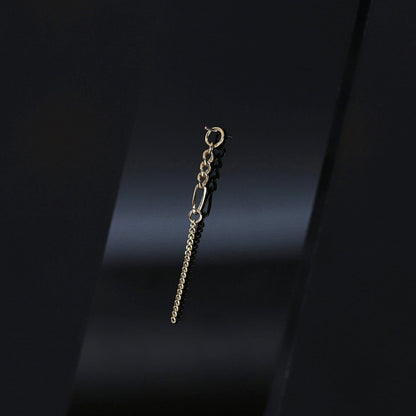 14K gold mixed-link drop chain charm on a dark background