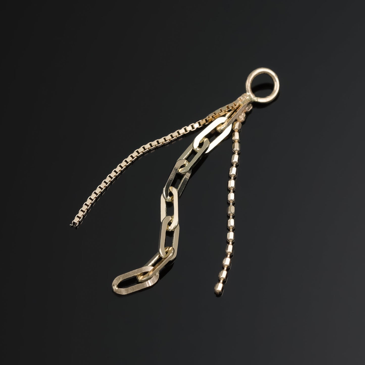 14K yellow gold mixed chain charm that comes with clip chain, box chain and ball chain displayed on black surface