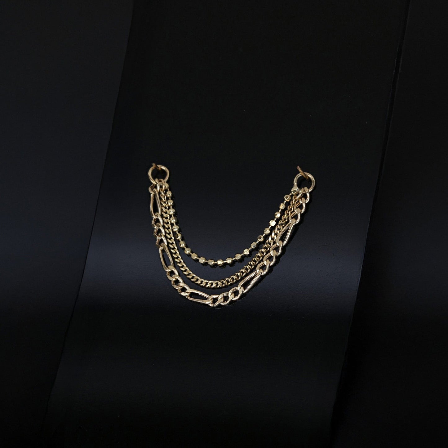 14K gold triple mixed chain attachment on a dark background