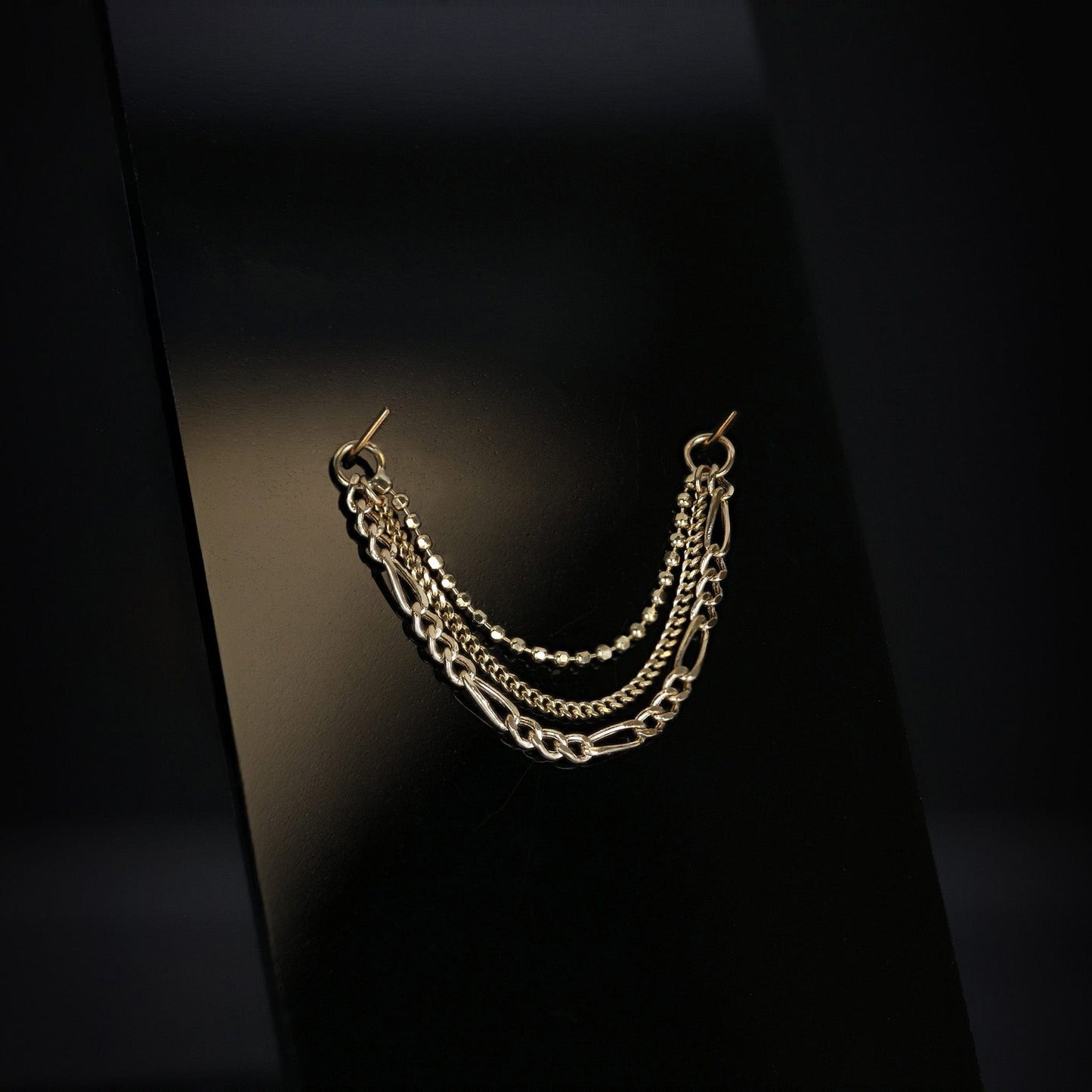 14K gold triple mixed chain attachment on a dark background