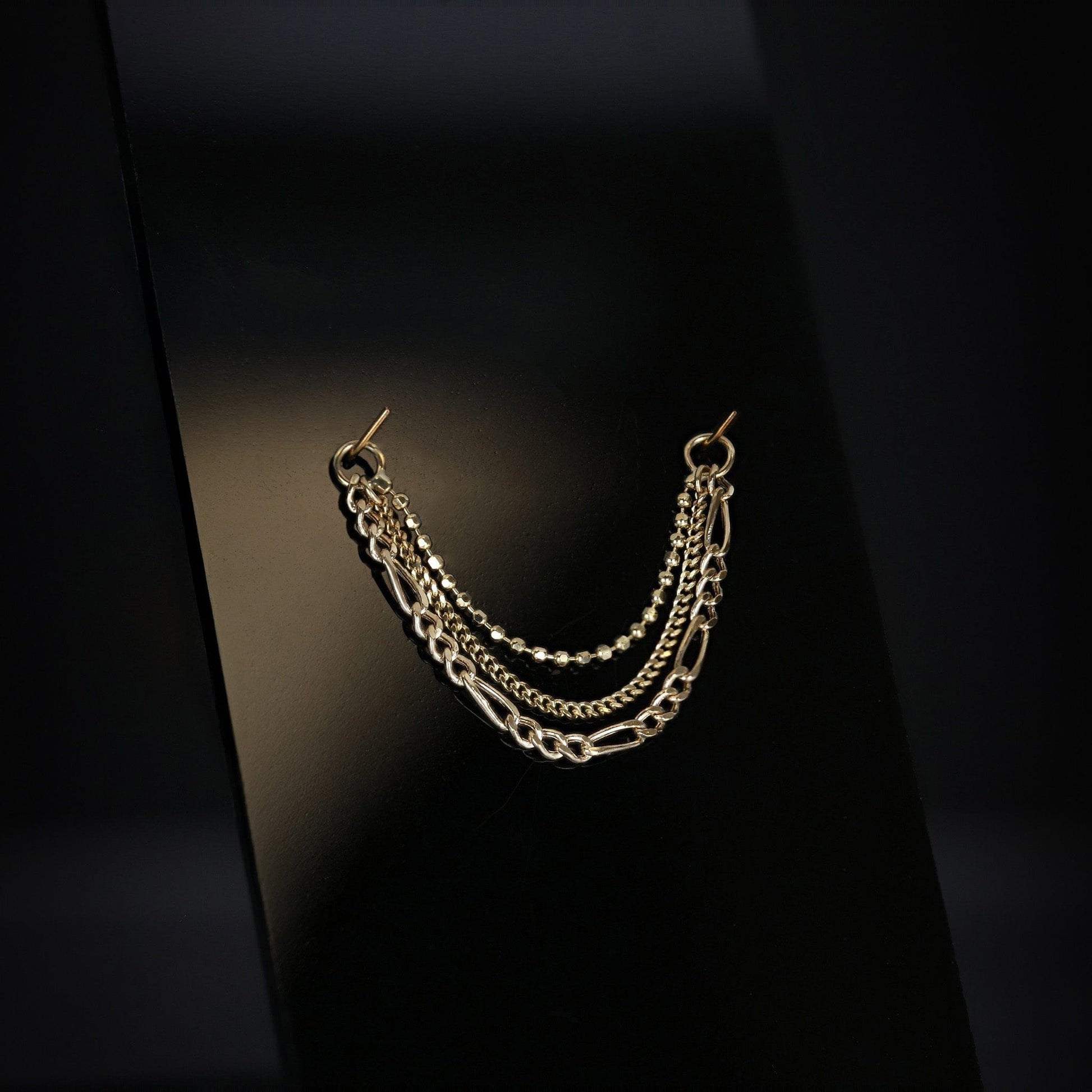 14K gold triple mixed chain attachment on a dark background