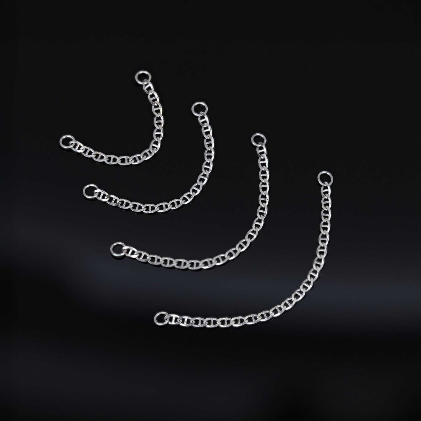 Four types of white gold chain attachments of different lengths on a black background