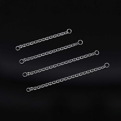 Four white gold chain attachments of varying lengths on a black background